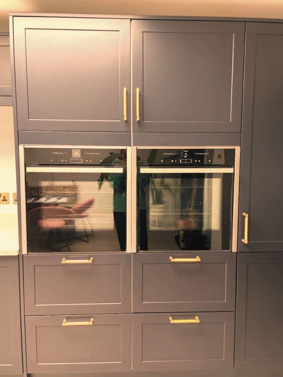 Built-in double oven in a grey fitted kitchen after cleaning